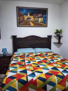 a colorful quilt on a bed in a bedroom at Casa Bella Vista in Santa Catarina Palopó