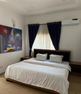 a bedroom with a large bed and a window at Q7 apartment in Gwarinpa