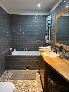 Un baño con bañera, lavabo y espejo. en Poleska Apartament, en Kielce