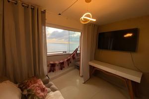 a bedroom with a large window with a view of the ocean at Flat praia a beira-mar in Natal