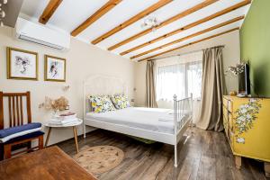 a small bedroom with a bed and a table at Къща за гости ЗЕЛЕНА in Vinogradets