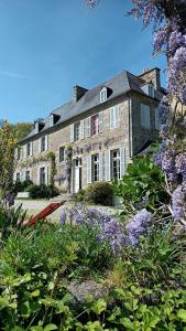 a large brick house with a yard with purple flowers at Manoir de charme Roz Maria - Parc clos in Quintin +46 photos