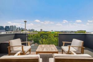 a patio with chairs and a table on a roof at Perch - Wanderlusts Hidden Gem in Seattle