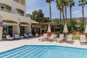 a pool at a resort with chairs and umbrellas at Hotel Corsica & Spa Serena in Calvi