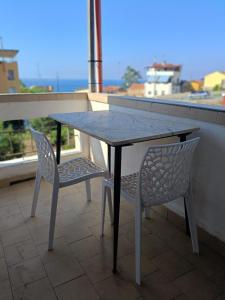 ein Tisch und zwei Stühle auf einem Balkon mit Aussicht in der Unterkunft Una Finestra sul mare in Villa San Giovanni