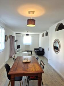 a living room with a wooden table and chairs at Le nid des agrumes in Lucciana
