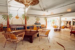 a dining room with a wooden table and chairs at Own Búzios Beach Hotel in Búzios