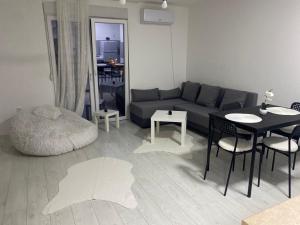 a living room with a couch and a table and chairs at Day and night in Prokuplje