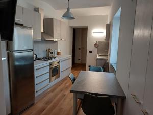 a kitchen with a table and a refrigerator at Da Ciro e Angela in Barolo