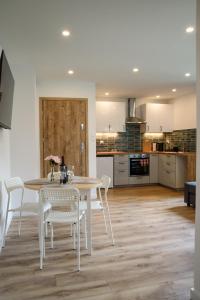 Una cocina y un comedor con mesa y sillas. en Lipowa Apartamenty, en Szczawno-Zdrój