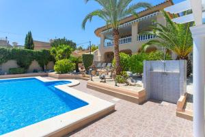 a villa with a swimming pool in front of a house at CH Villa Jupiter La Marquesa in Rojales