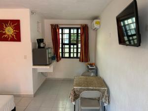 a room with a table and a television in a room at Casa Cuevas & Amaro in Mérida