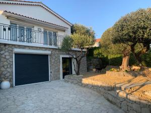 a house with a garage door and a driveway at studio indépendant plain pied jardin & piscine in Grasse
