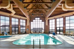 a large indoor pool in a building with windows at Cedar Shore Resort in Oacoma