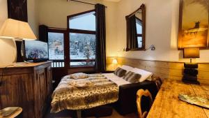 una camera da letto con un letto e una grande finestra di Appartement Le Cerf- T2 sur front de neige - LA TANIA a Courchevel