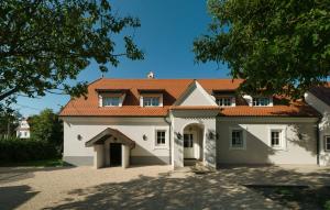a large white house with a red roof at The Szekler Countryside Estate in Bicfălău