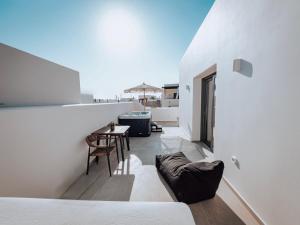 a room with white walls and a table and a couch at Nonna's Suites in Naxos Chora
