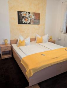 a bedroom with a large bed with yellow pillows at Pension zum Reiterhof, Doppelbettzimmer in Schmogrow