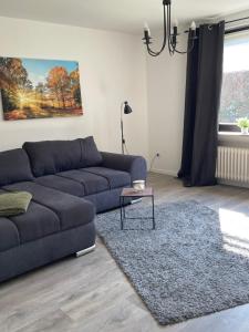 a living room with a couch and a table at Ferienwohnung Appartement am Wildpark Bad Harzburg in Bad Harzburg +2 photos