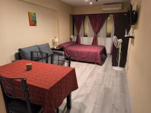 Una habitación de hotel con una cama, una mesa y un sofá. en Monoambiente a 300 metros del Obelisco, en Buenos Aires