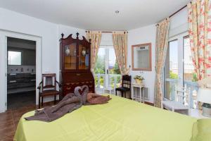 a bedroom with a green bed and a clock at CH Villa Jupiter La Marquesa in Rojales +66 photos