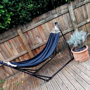 a hammock on a deck with a potted plant at Room in bungalow in Alness