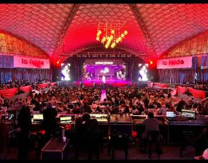 a large crowd of people sitting in a large auditorium at El Espinillo in La Falda +49 photos
