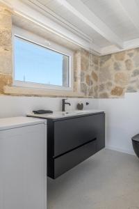 a bathroom with a sink and a window at Milo Stone Villas in Zefiría