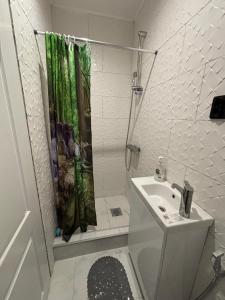 een witte badkamer met een douchegordijn en een wastafel bij Wood & Chill House in Sarajevo