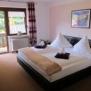 een slaapkamer met een groot bed met kussens erop bij Hotel Sonnleitn in Bodenmais