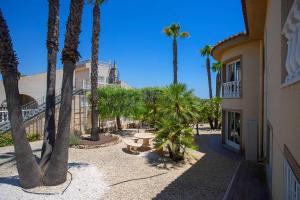 a group of palm trees next to a building at CH Villa Jupiter La Marquesa in Rojales