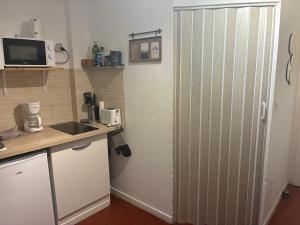 a kitchen with a large white refrigerator in a room at Cocoon 3 - Studio bohème rénové Centre historique Beaucaire in Beaucaire