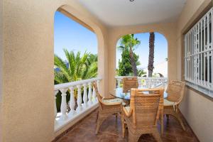 a balcony with a table and chairs and palm trees at CH Villa Jupiter La Marquesa in Rojales