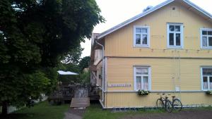 a yellow house with a bike parked in front of it at Majatalo Martta in Nauvo