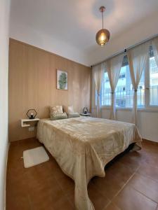 a bedroom with a large bed with two windows at Departamento Las Heras in Mar del Plata