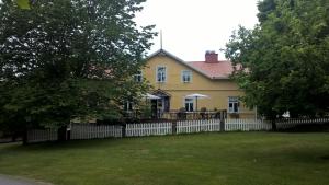 a yellow house with a fence in front of it at Majatalo Martta in Nauvo