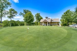 a golf green with a house in the background at Cashiers Getaway with Decks and Golf Course Views in Cashiers