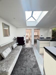 a living room with a couch and a kitchen with a skylight at 2 Bed-Sleeps 5-Free Parking-Pet Friendly in High Wycombe