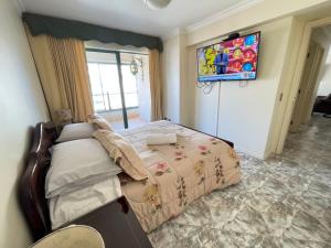 um quarto com uma cama e uma TV na parede em Departamento Vistas Panorámicas em Viña del Mar mais 6 fotografias