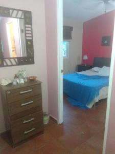 a bedroom with a bed and a dresser and a mirror at Las Lajas Chalet Sweet home 2 bedrooms in Las Lajas