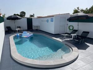 a swimming pool with a inflatable raft in a backyard at Refúgio do Mira in Vila Nova de Milfontes