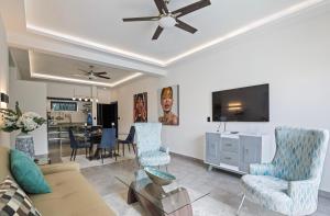 a living room with a couch and a flat screen tv at Instyle Residences at RIZZ SUITES in Sosúa