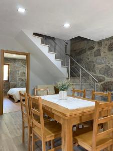 a dining room with a table and a staircase at Refúgio do Bugalho in Picão