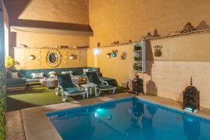 a house with a swimming pool and a living room at Riad Benyara in Taroudant