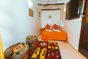 a bedroom with a bed and a chair and a rug at Riad Benyara in Taroudant +40 photos