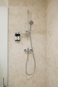 a shower with a shower head in a bathroom at Moorea Beach Villas in Haapiti