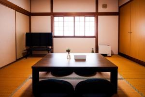 富山ゆるりたび的带桌子和电视的客厅