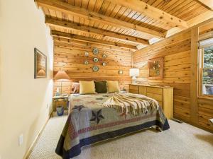 a bedroom with a bed and a wooden wall at Top of the Line Asheville Mountain Cabin in Leicester