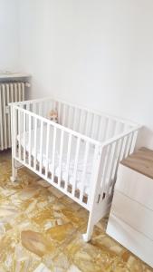 a white crib in a room with a table at Sunrise in Bergamo +1 photo