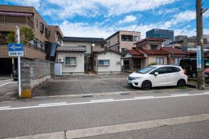 a white car parked on the side of a street at ゆるりたび in Toyama